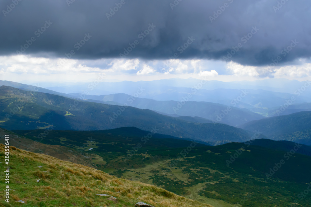 Panoramic view on thunderstorm clouds from Hoverla, Carpathian mountains, Ukraine. Horizontal outdoors shot