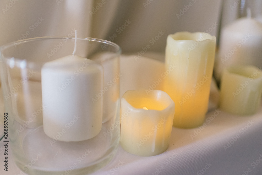 Lighted candles on a white tablecloth Lighted candles on a white tablecloth