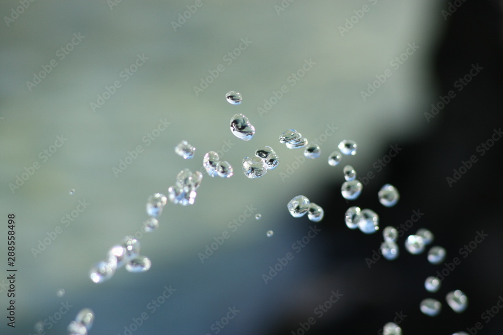 Glasklares Wasser spritzt aus einem Trinkwasser Brunnen, eingefroren wie Glasperlen 1