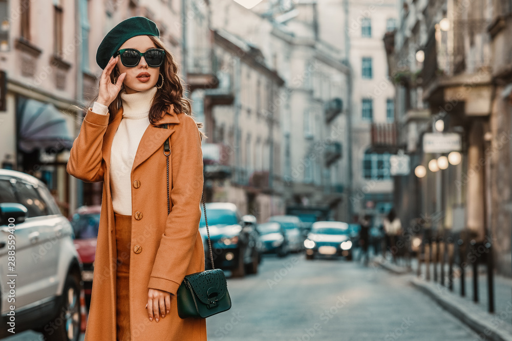 Outdoor autumn portrait of young elegant fashionable woman wearing trendy  sunglasses, camel color coat, turtleneck, with textured leather shoulder  bag, walking in street of European city. Copy space Stock Photo | Adobe