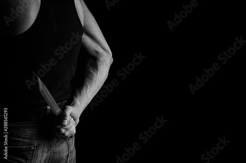 Man hiding a knife behind his back