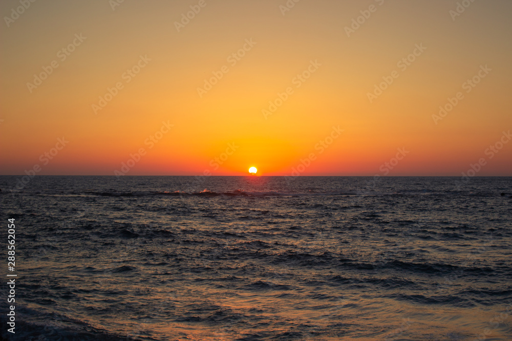 idyllic picturesque nature poster wallpaper photography of sunset orange lighting above wavy sea water surface Mediterranean romantic moody scenery landscape view 