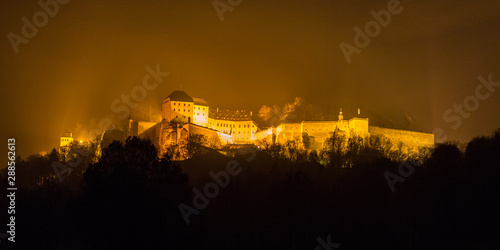 The fortress Koenigstein shrouded in fog at night, Germany