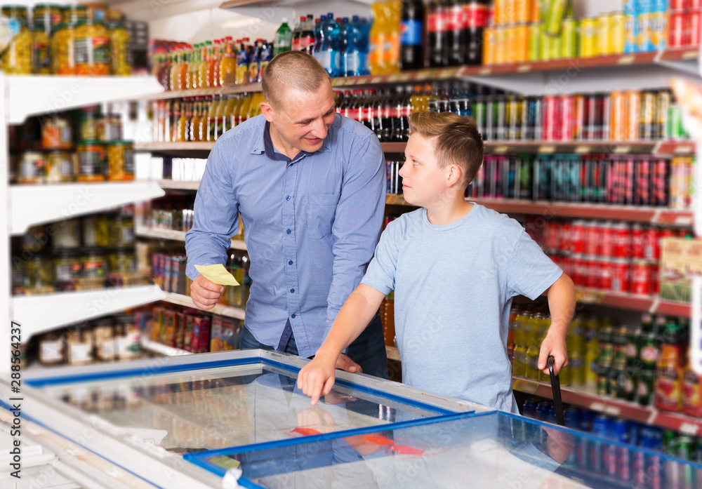 Father doing shopping with boy looking at shopping list