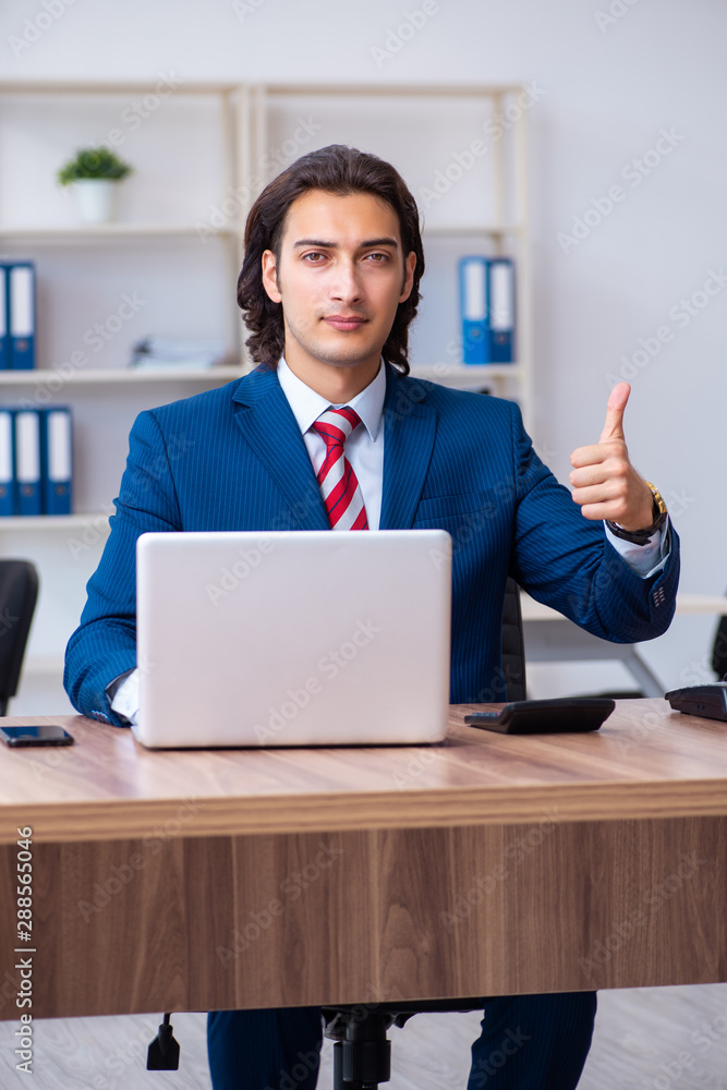 Young male businessman working in the office Young male businessman working in the office