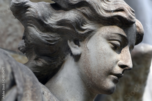 Partial view of the face of an old sandstone sculpture of an angel. photo