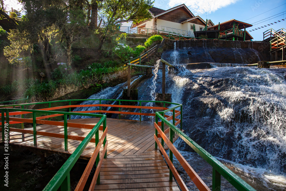 Tourists on outdoor adventure and natural waterfall Ducha de Plata (silver fall) in the Campos do Jordao mountains Serra da Mantigueira