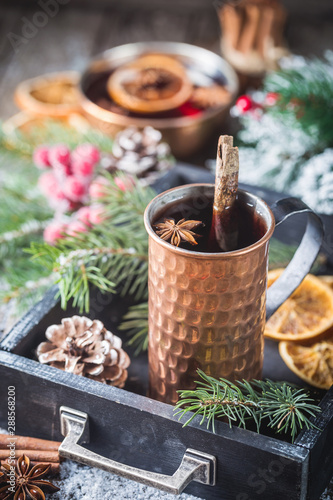 Fototapeta Naklejka Na Ścianę i Meble -  Christmas mulled red wine with spices and fruits on a wooden rustic table. Traditional hot drink at Christmas time