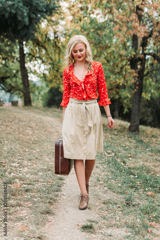 Beautiful lady, girl retro fashion, holding an old suitcase walking Beautiful lady, girl retro fashion, holding an old suitcase walking