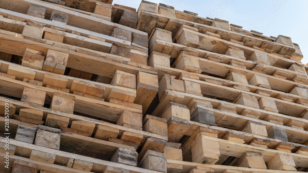 Wooden euro pallets for transfering goods to customers. Used wooden pallets in stack in the warehouse. Wooden pallet overlap. Wooden euro pallets for transfering goods to customers. Used wooden pallets in stack in the warehouse. Wooden pallet overlap.