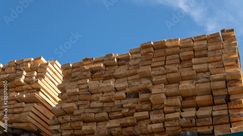 Wooden boards  lumber  industrial wood  timber. Pine wood timber stack of natural rough wooden boards on building site. Industrial timber building materials