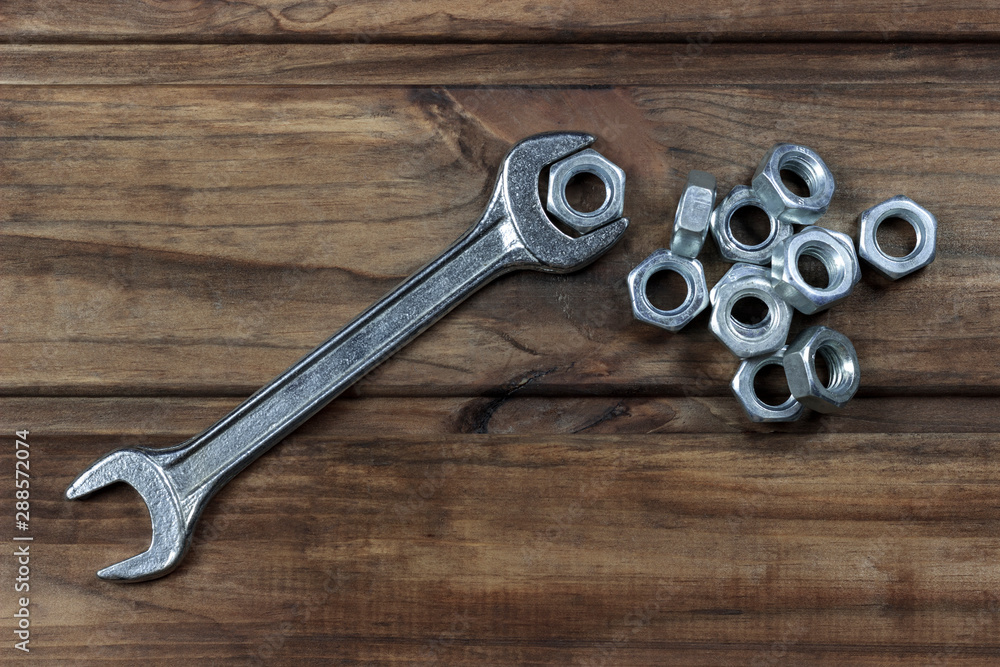 wrench and nuts on a wooden background, place for an inscription wrench and nuts on a wooden background, place for an inscription