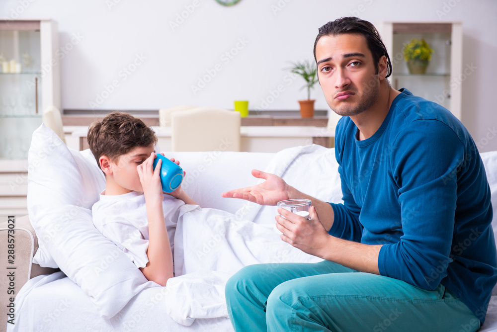 Obraz premium Young father caring for sick son