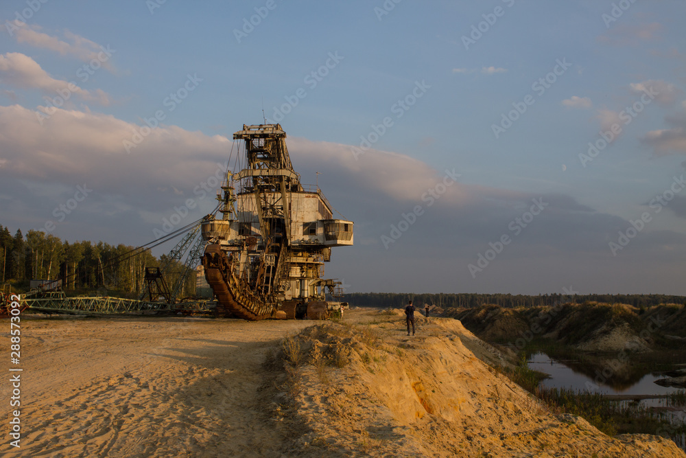 Fototapeta premium multi-bucket excavator giant at limestone quarry in summer day