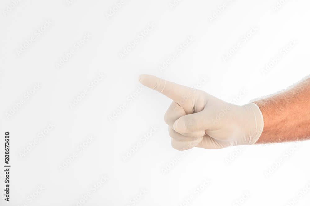 Man's hand covered by a medical glove, gesturing with his finger on a white background. Space for writing.