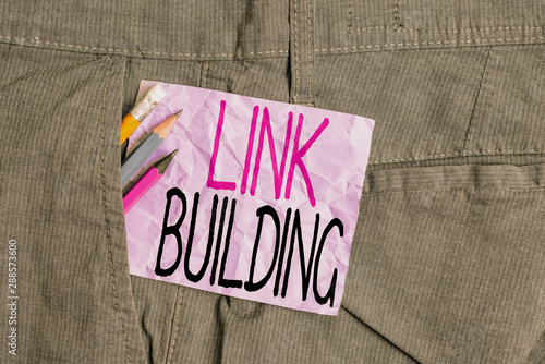 Conceptual hand writing showing Link Building. Concept meaning SEO Term Exchange Links Acquire Hyperlinks Indexed Writing equipment and purple note paper inside pocket of trousers