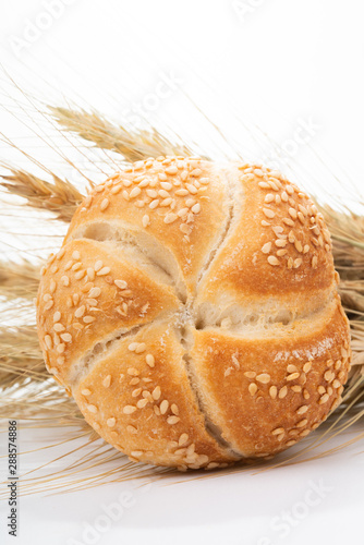 Fresh bread and spikes on white background