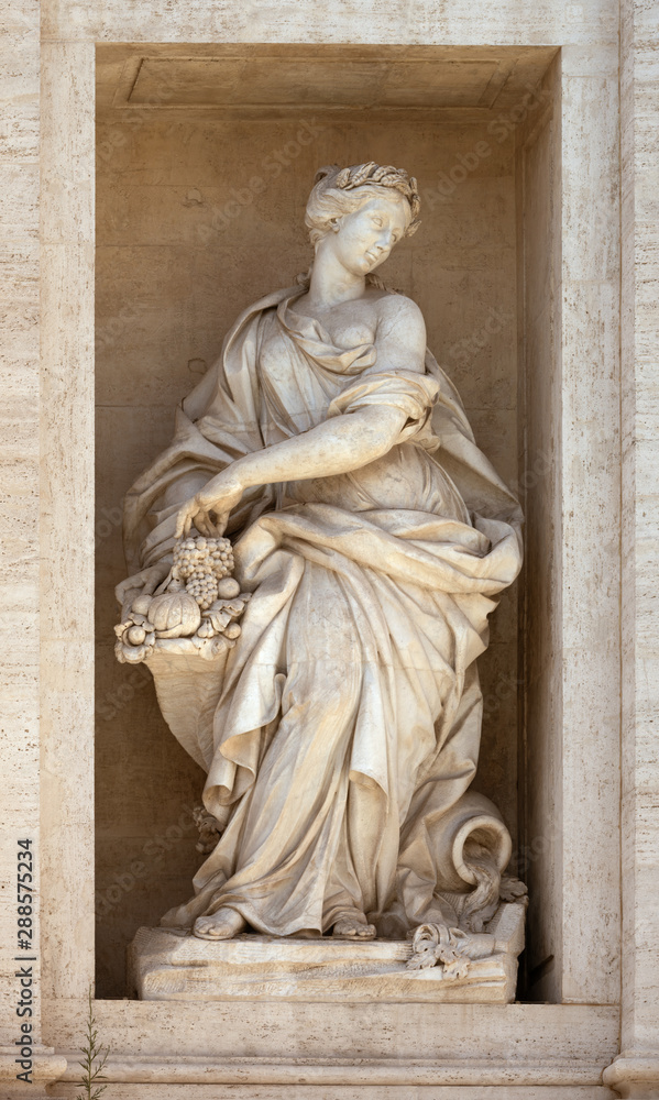 Statue of Abundance of Fruits with a horn of plenty. Detail of the Trevi fountain, Rome, Italy