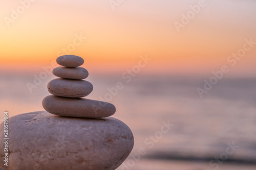 Perfect balance of stack of pebbles at seaside towards sunset. Concept of balance  harmony and meditation. Helping or supporting someone for growing or going higher up.