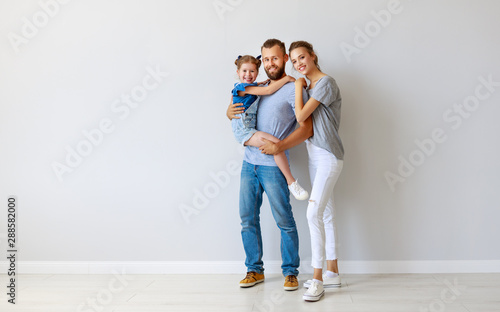 happy family mother father and child near an empty wall