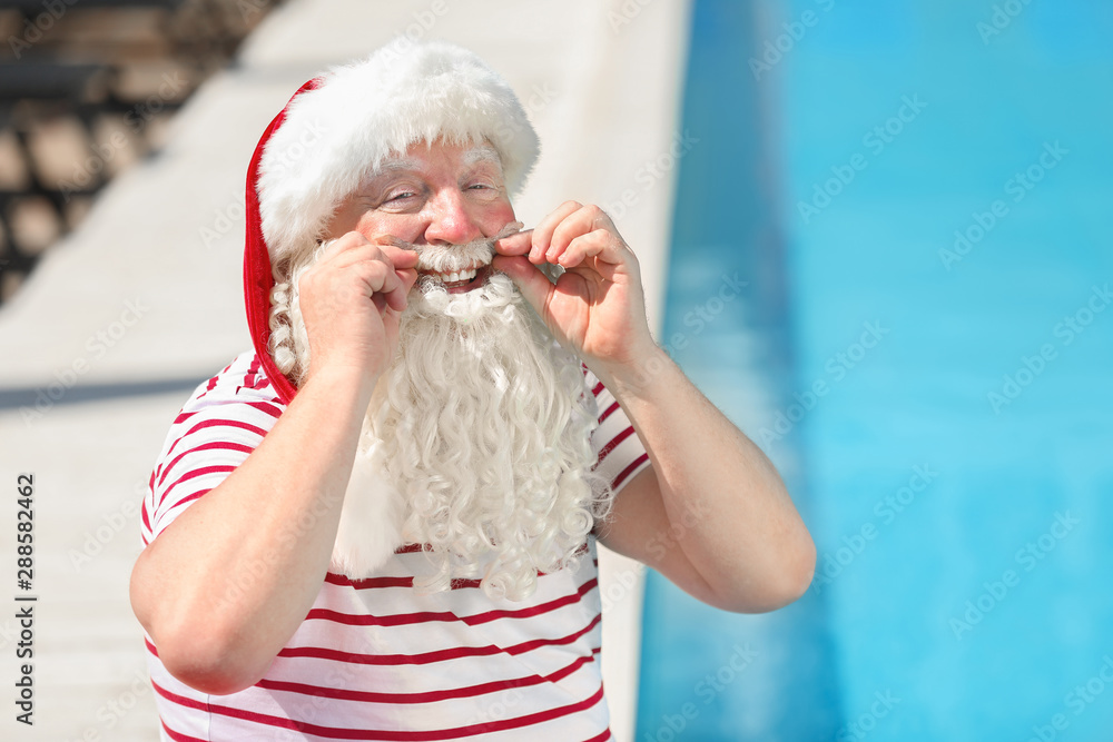 Obraz premium Santa Claus near swimming pool at resort