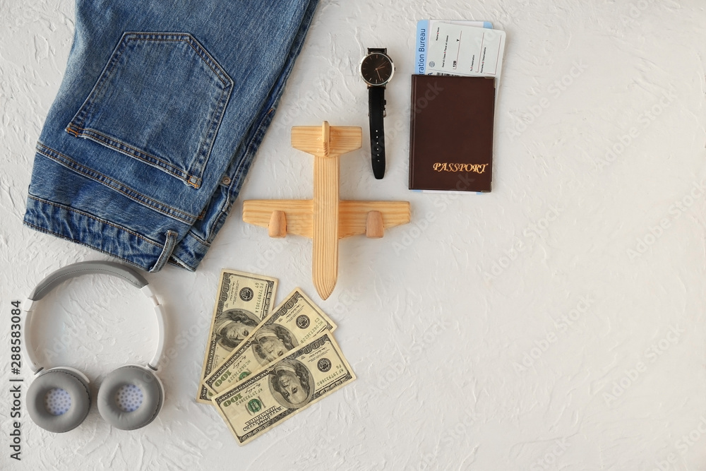 Composition with jeans, passport, tickets, money and headphones on white background