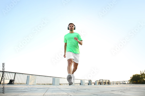 Handsome sporty man listeni...