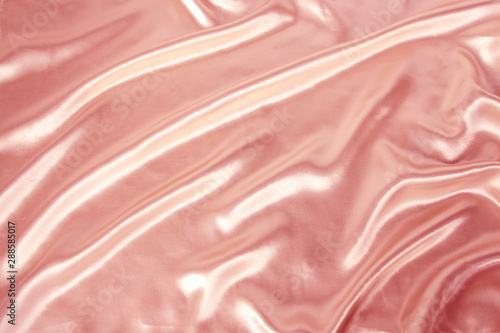 soft folds on delicate pink shiny silk, luxury concept, background for the designer, horizontal, close-up, copy space