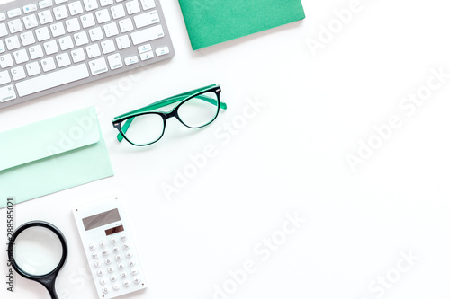Creative work desk with green supplies on white background flat lay copy space top view