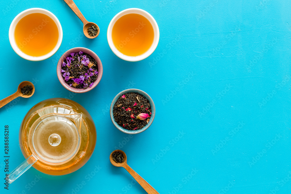 Cups, teapot, dry tea on blue background top view mockup Cups, teapot, dry tea on blue background top view mockup