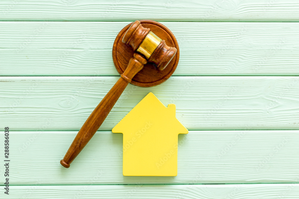 Inheritance of the house concept with figure and gavel on mint green wooden background top view Inheritance of the house concept with figure and gavel on mint green wooden background top view