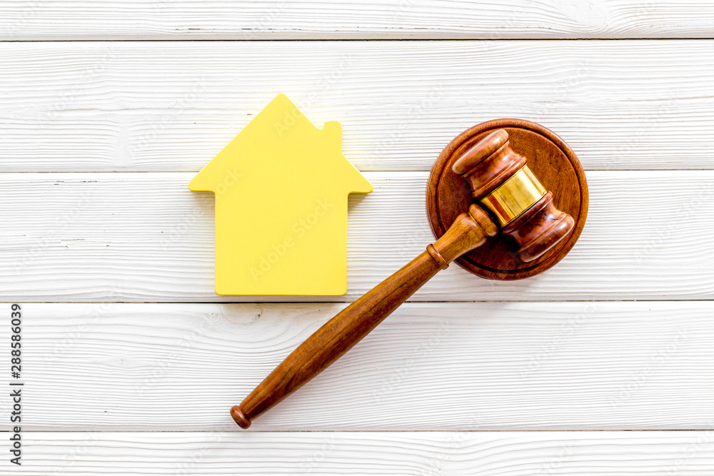 Inheritance of the house concept with figure and gavel on white wooden background top view Inheritance of the house concept with figure and gavel on white wooden background top view