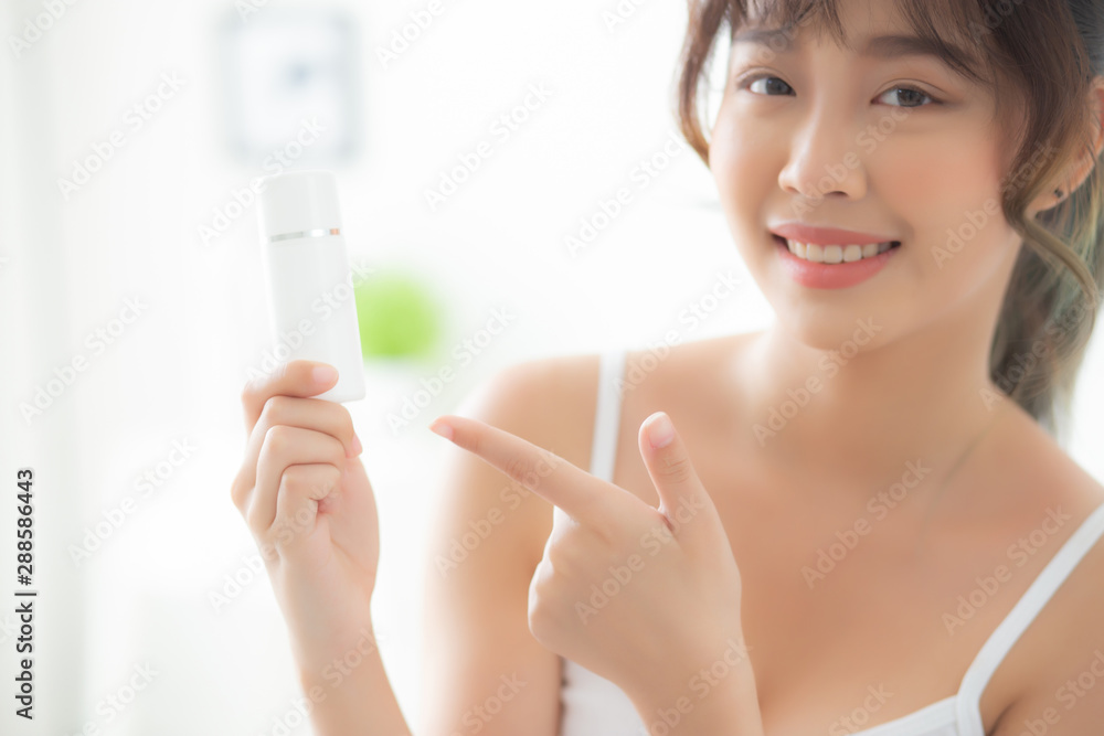 Beautiful portrait young asian woman holding and pointing presenting cream or lotion product, beauty asia girl show cosmetic makeup and moisturizing for skin care, healthy and wellness concept. Beautiful portrait young asian woman holding and pointing presenting cream or lotion product, beauty asia girl show cosmetic makeup and moisturizing for skin care, healthy and wellness concept.