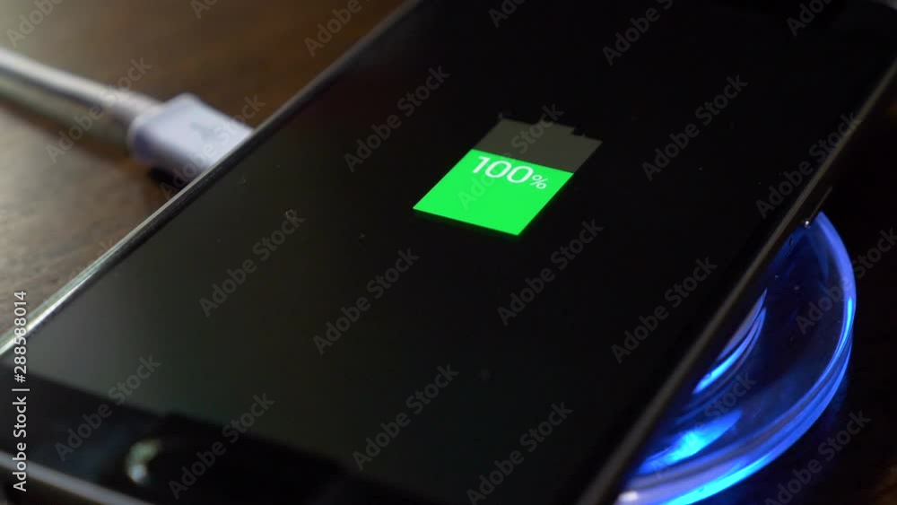 Smartphone charging on a charging pad. Closeup Wireless charging Smartphone charging on a charging pad. Closeup Wireless charging