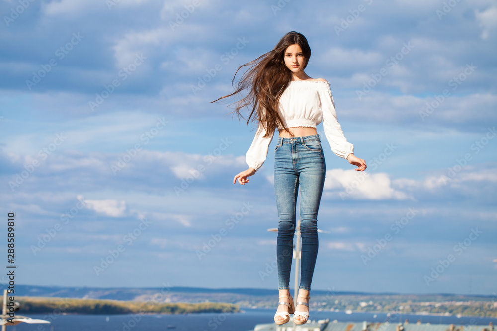 Pretty stylish brunette girl in blue jeans and white blouse Pretty stylish brunette girl in blue jeans and white blouse