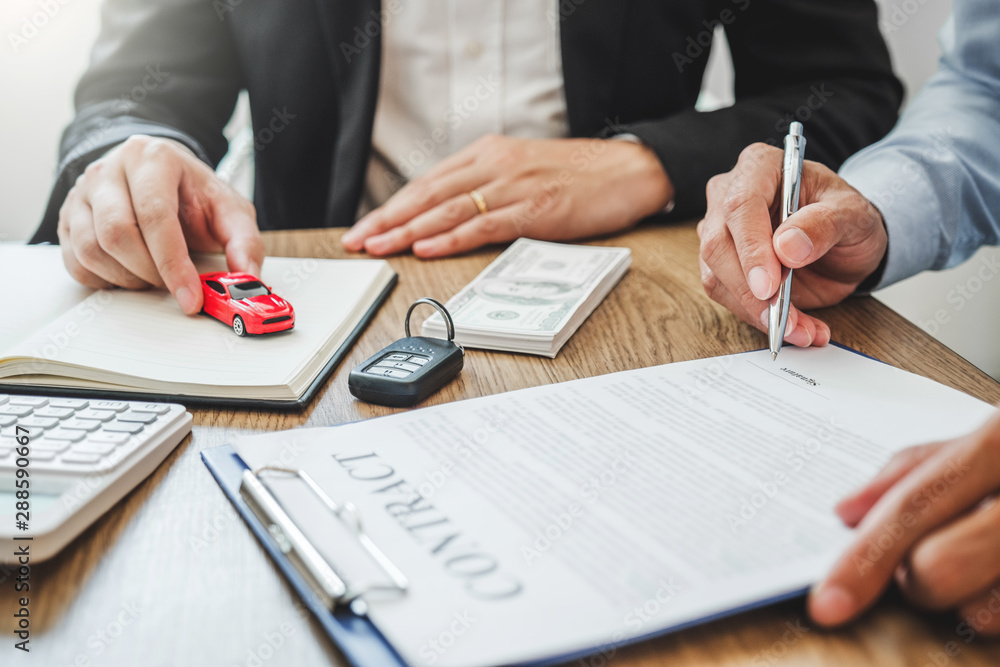 Sale agent deal to agreement successful car loan contract with customer and sign agreement contract Insurance car concept. Sale agent deal to agreement successful car loan contract with customer and sign agreement contract Insurance car concept.