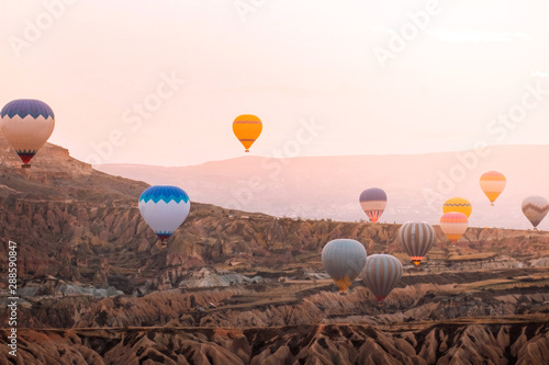 Colorful hot air balloons flying over the valley at Cappadocia sunrise time popular travel destination in Turkey