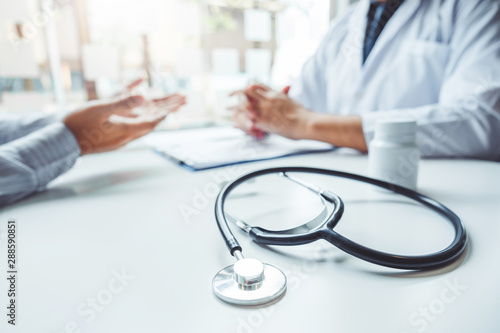 Doctors and patients consulting and diagnostic examining sit and talk. At the table near the window in the hospital medicine concept photo