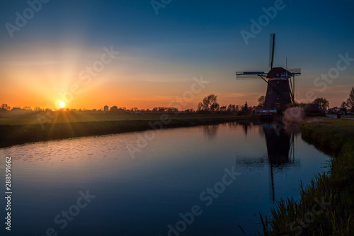 Sunset behind a 17th century windmill at Driemanspolder, near The Hague, The Netherlands.