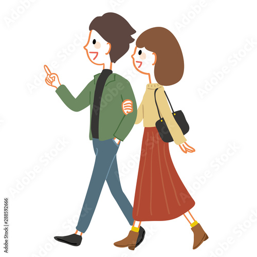 腕を組んで歩く若いカップル　秋服