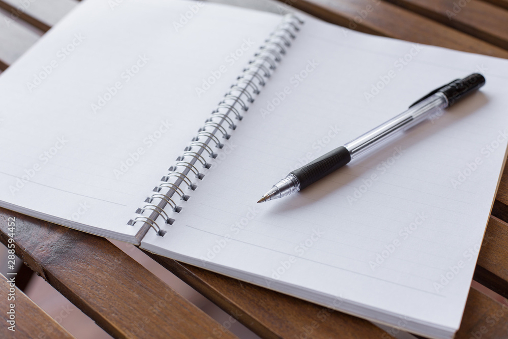 Selective focus of Pen, notebook on the wooden table and copy space Selective focus of Pen, notebook on the wooden table and copy space