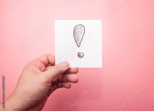 hand holding sticker with exclamation mark isolated on pink background photo