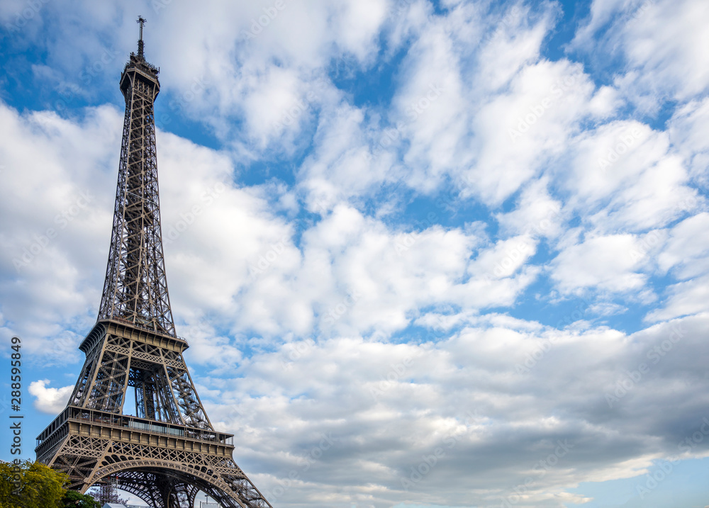 Fototapeta premium Eiffel Tower rests against the spire in the clouds