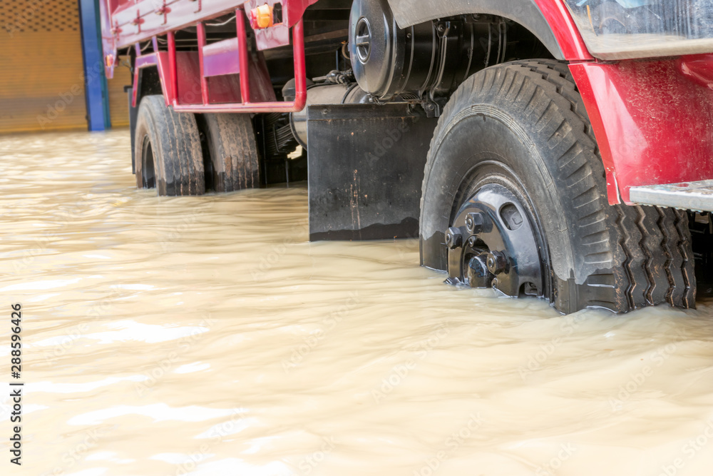 Fototapeta premium Car driving on a flooded road, The broken car is parked in a flooded road. .