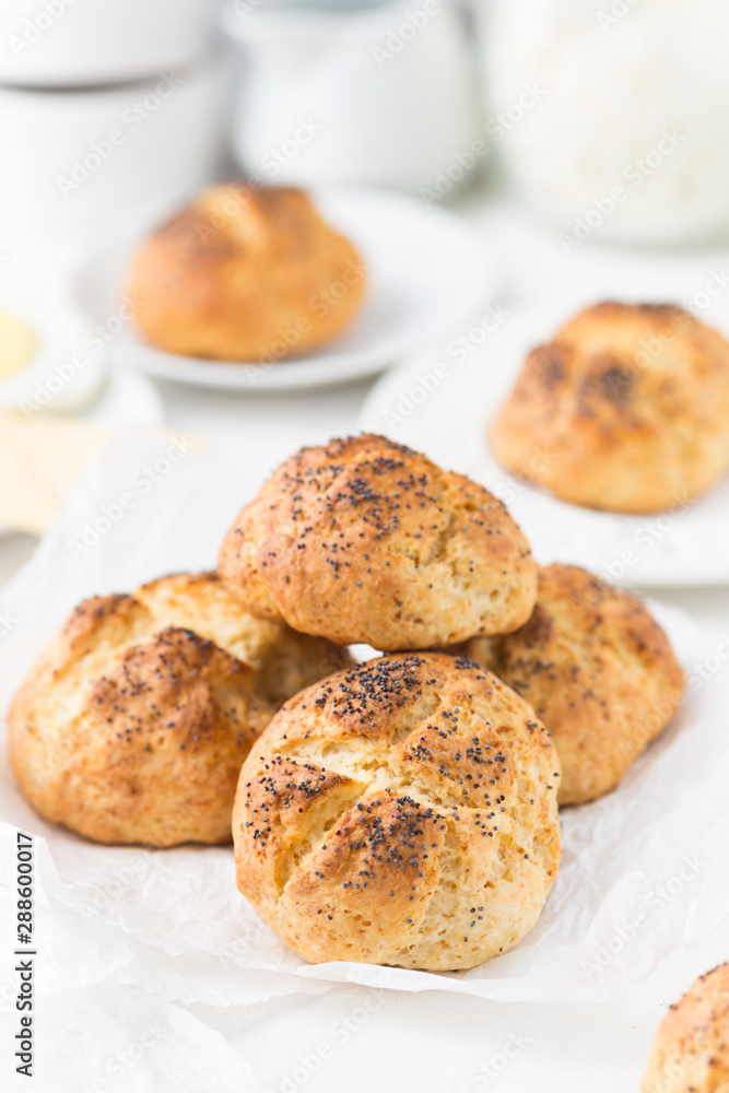 Homemade cheese buns with poppy seeds on a white 