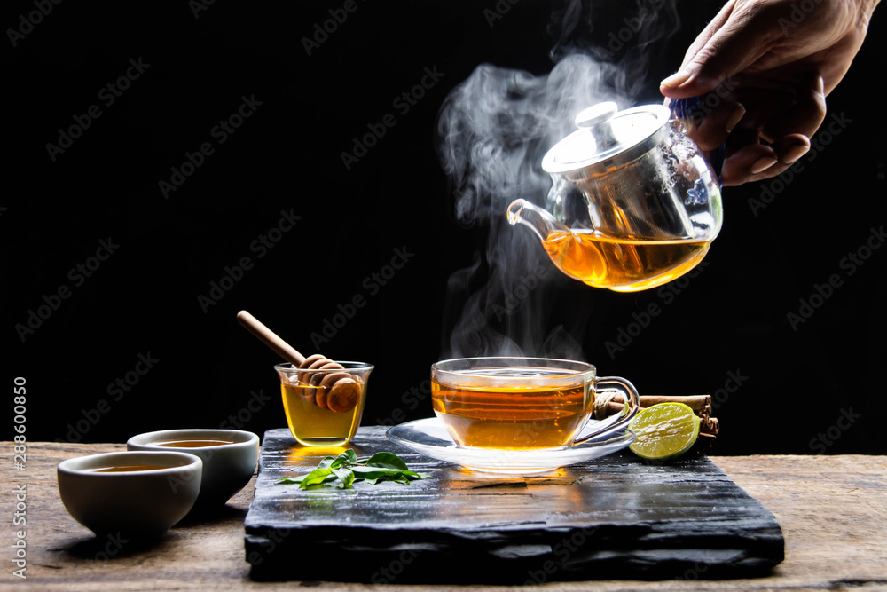 Healthy hot tea with hot steam, honey water and a cup of beautifully placed tea. - Healthy herbal water concept Healthy hot tea with hot steam, honey water and a cup of beautifully placed tea. - Healthy herbal water concept