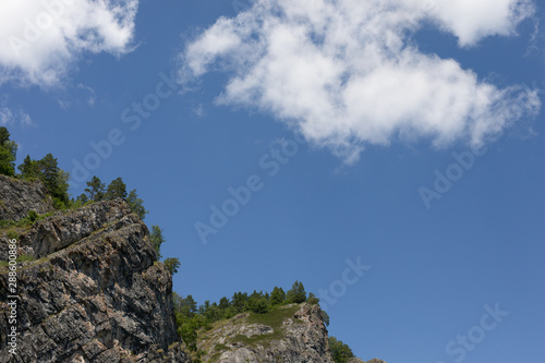 Bright blue sky in the mountains. clouds come up from the tops of the mountains