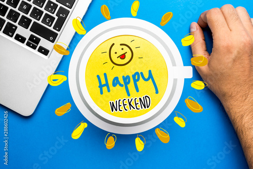 Photography Happy weekend quote and coffee cup on blue background with laptop computer and hand resting over desk