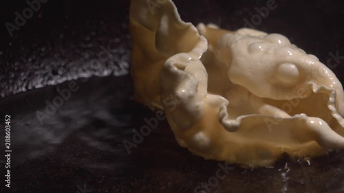 Crunchy Indian Flatbread frying up in hot oil close up in pan