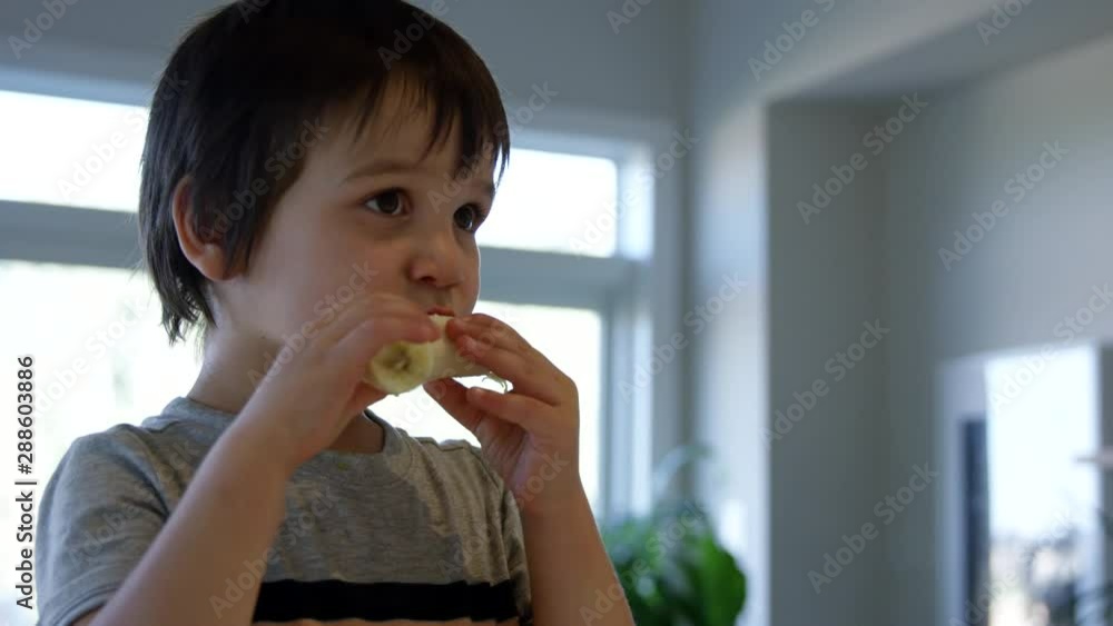 Toddler boy taking bites out of banana - close up Toddler boy taking bites out of banana - close up